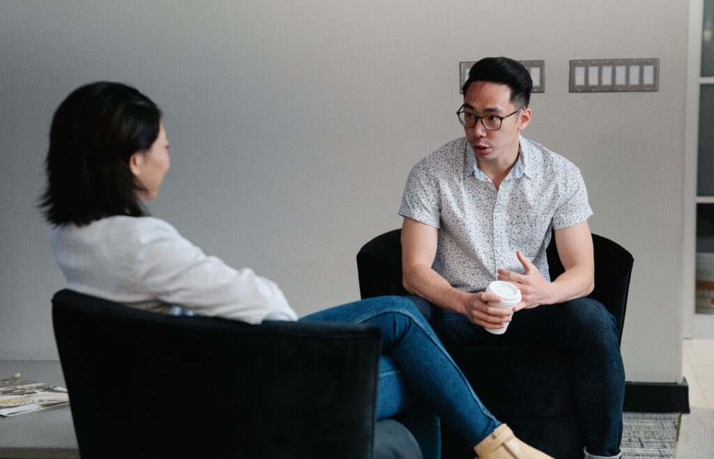 Two colleagues in a relaxed conversation over coffee, the kind of genuine working session that strengthens collaboration between subject matter experts and instructional designers