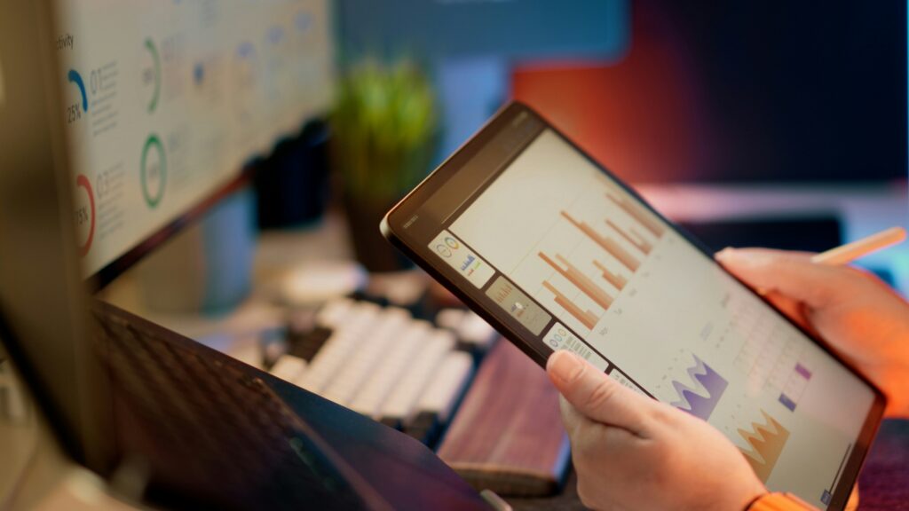 Professional reviewing performance data and charts on a tablet, the kind of framework review that goes into building a training measurement plan